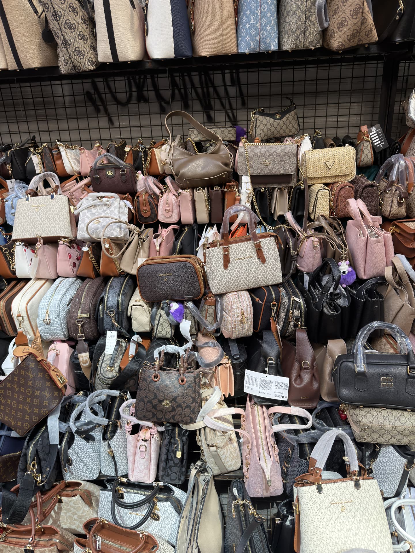 Wall of imitation-style handbags and purses
