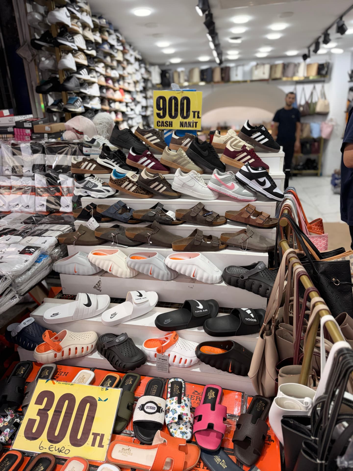 Crowded shoe and accessory shop with sneakers and sandals